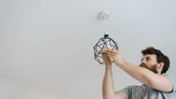 Man screwing light bulb into lamp