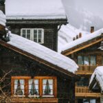 Wooden houses covered with snow in mountainous valley in winter
