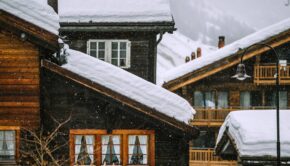 Wooden houses covered with snow in mountainous valley in winter