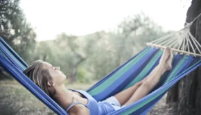Woman in Blue Tank Top Lying on Blue and Green Stripped Hammock