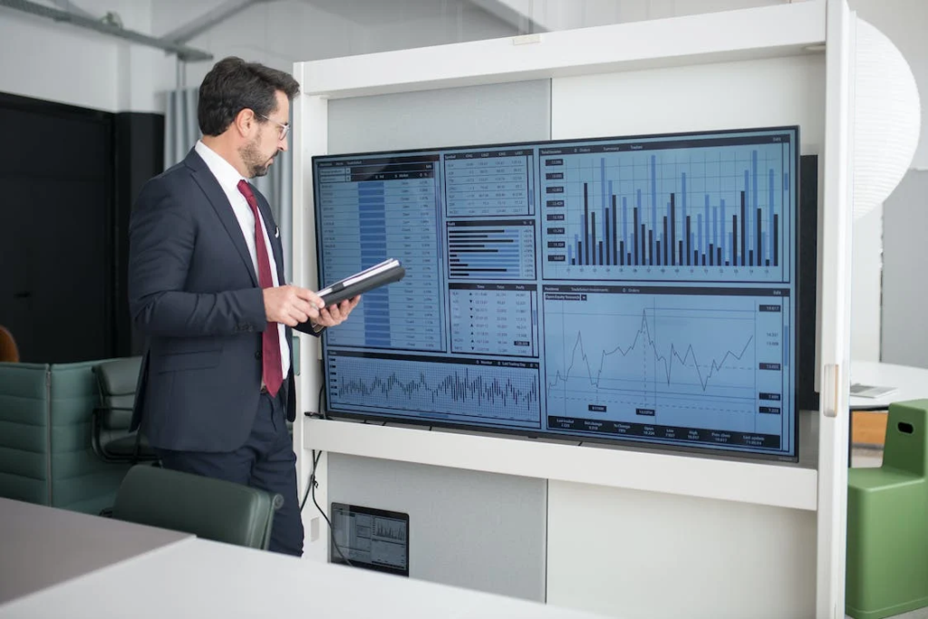 man looking at a wide screen monitor.