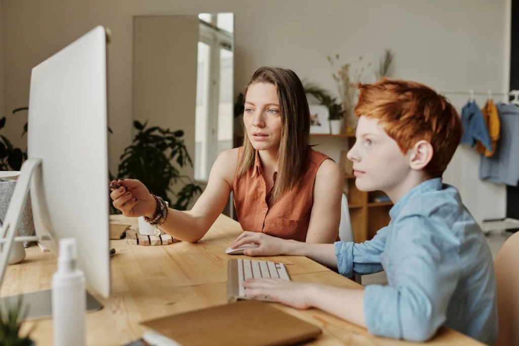 photo of woman tutoring young boy