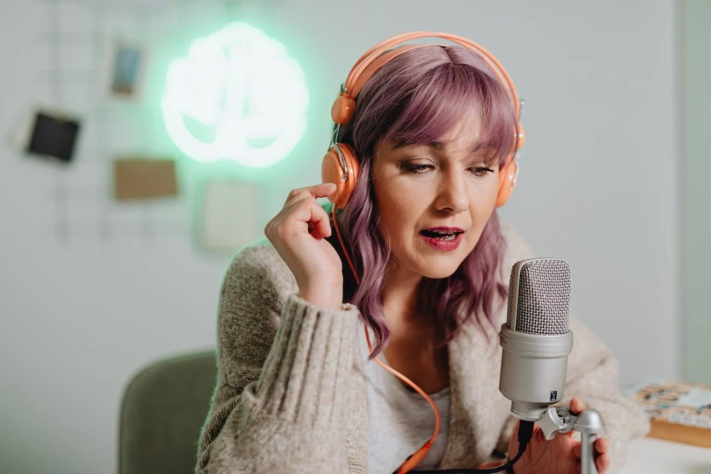 a woman talking on a microphone while wearing a headphone