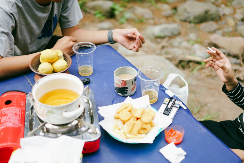 Two people sitting by the table with food and drinks