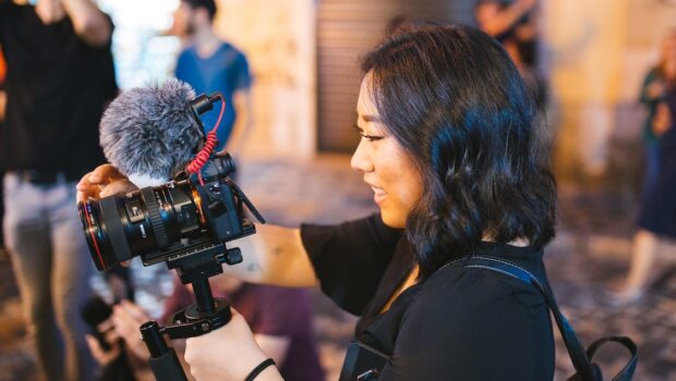 smiling woman holding black dslr camera