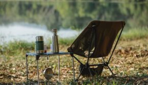 camping chair near table on river shore