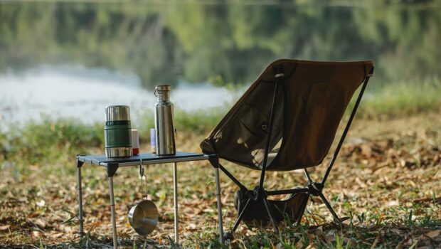 camping chair near table on river shore