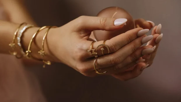 Person Wearing Gold Rings and Gold Bracelets