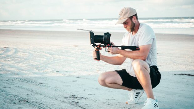 Man Holding Black Dslr Camera Outdoors