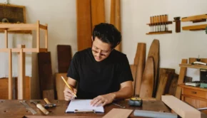 Focused ethnic craftsman working in creative carpenter studio