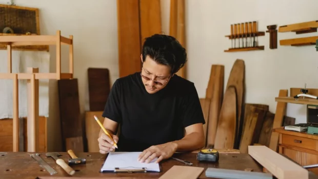 Focused ethnic craftsman working in creative carpenter studio