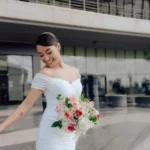 Girl Holding a Bouquet of Flowers in Front of a Glass Building