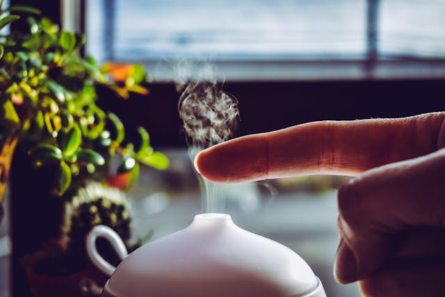 A person putting their finger above the oil diffuser